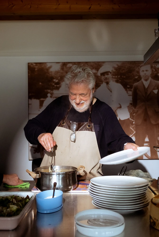A joyful scene in a kitchen, an elderly man and two women cook together.