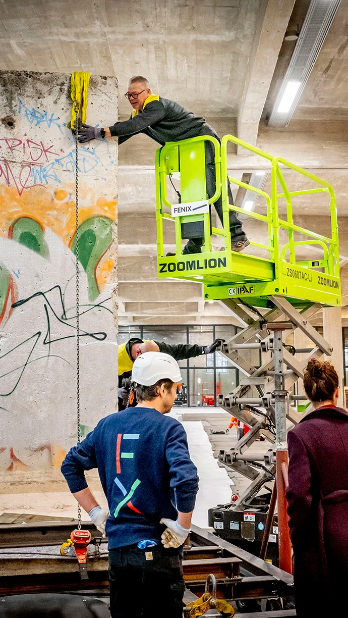 Medewerkers installeren een stuk van de Berlijnse muur in Fenix.