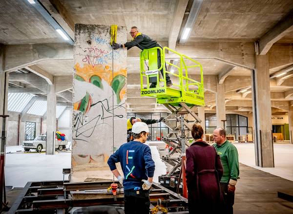 Medewerkers installeren een stuk van de Berlijnse muur in Fenix.
