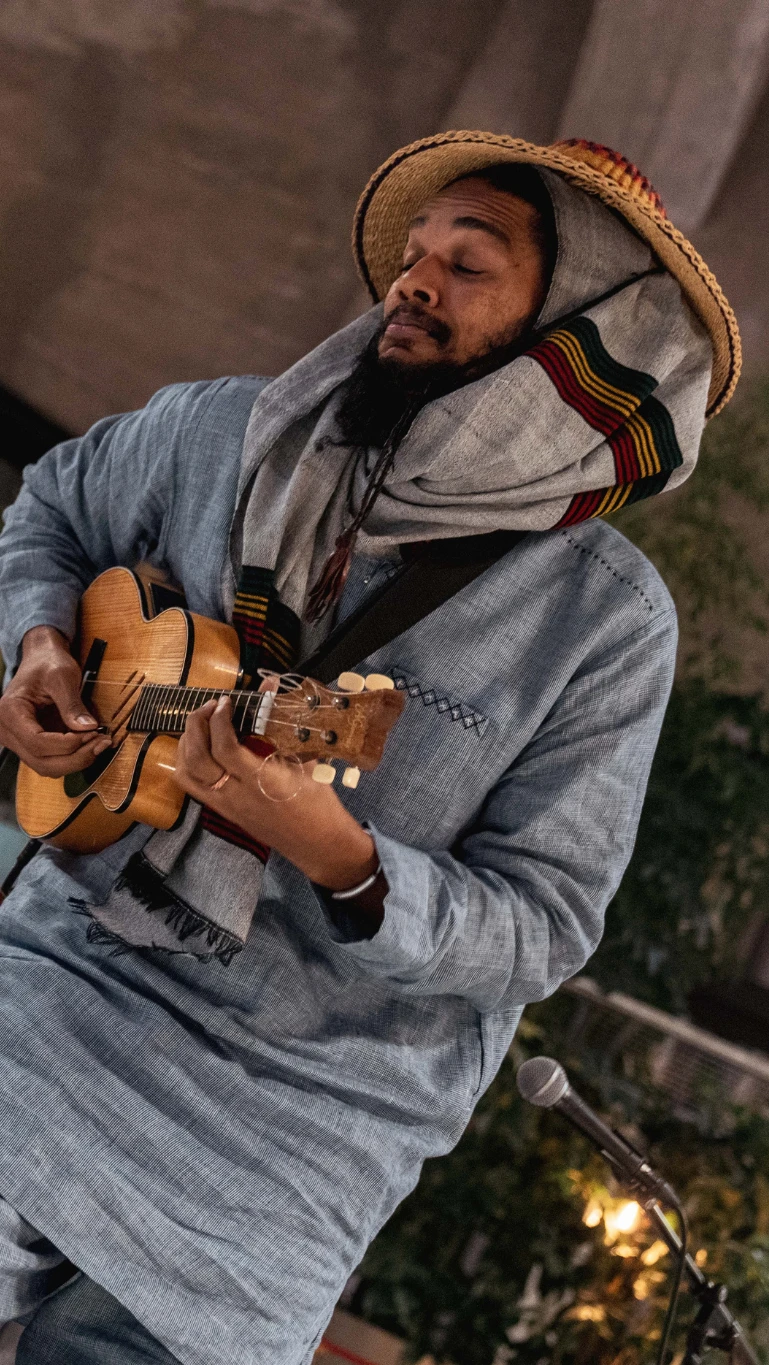 Two musicians play guitars together on stage at the African Food Festival.