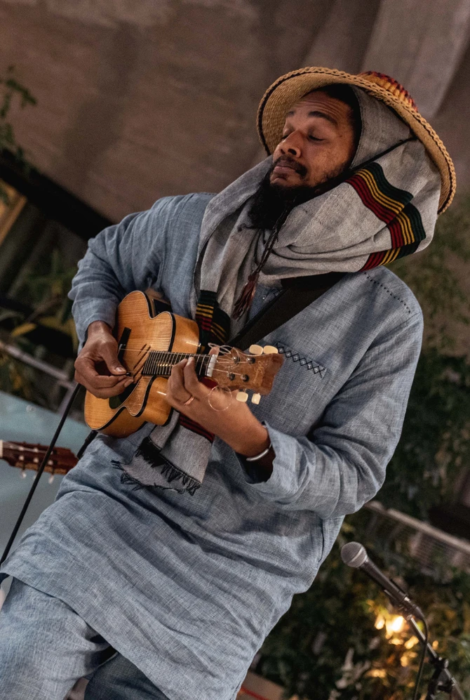 Two musicians play guitars together on stage at the African Food Festival.