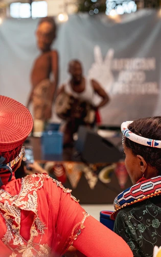 A performer plays a traditional drum on stage at the African Food Festival.