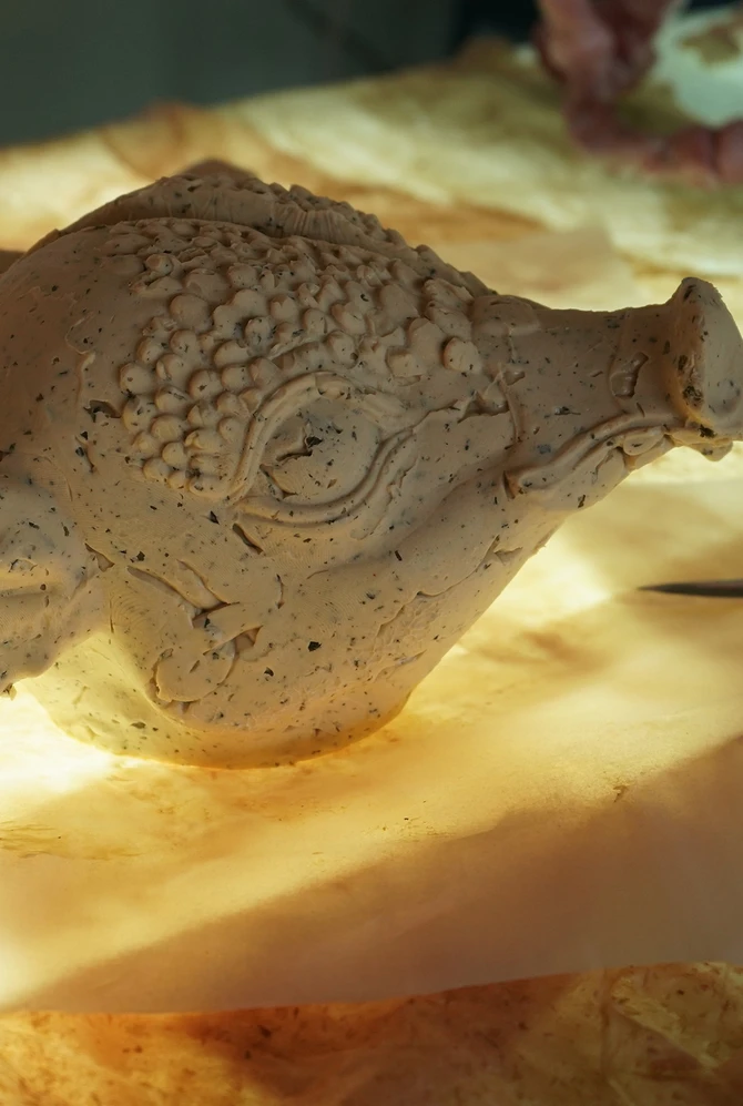 a pig head made of butter on a table lit warmly from underneath