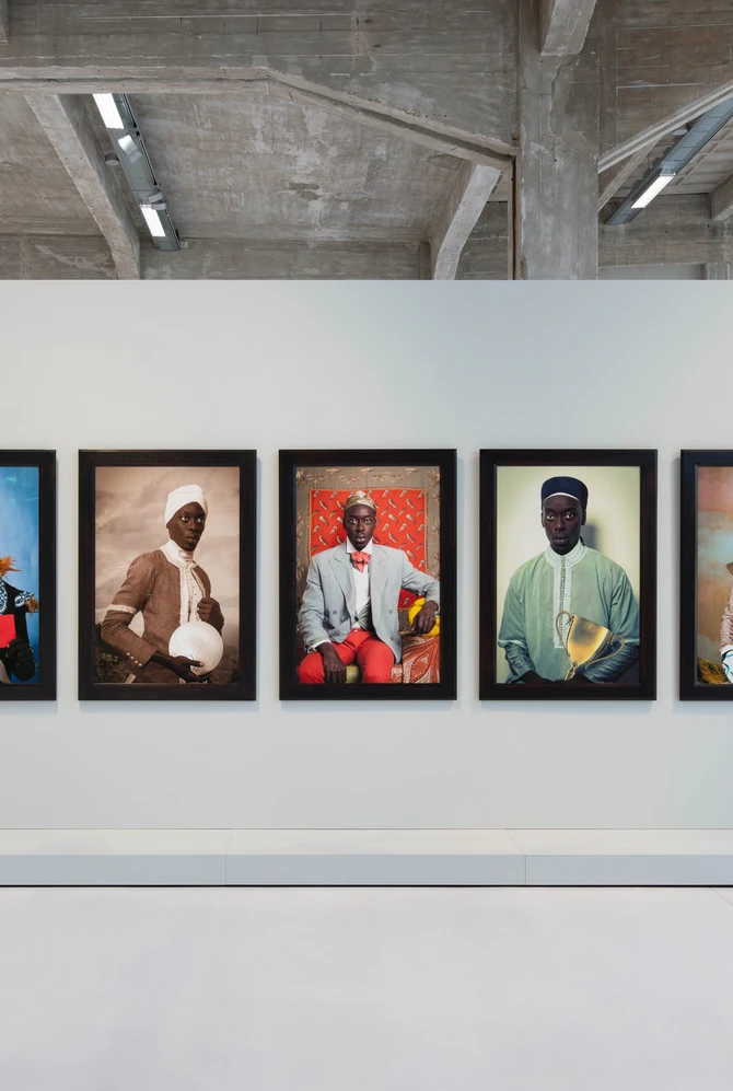 Five framed photographic portraits displayed on a white gallery wall inside Fenix.