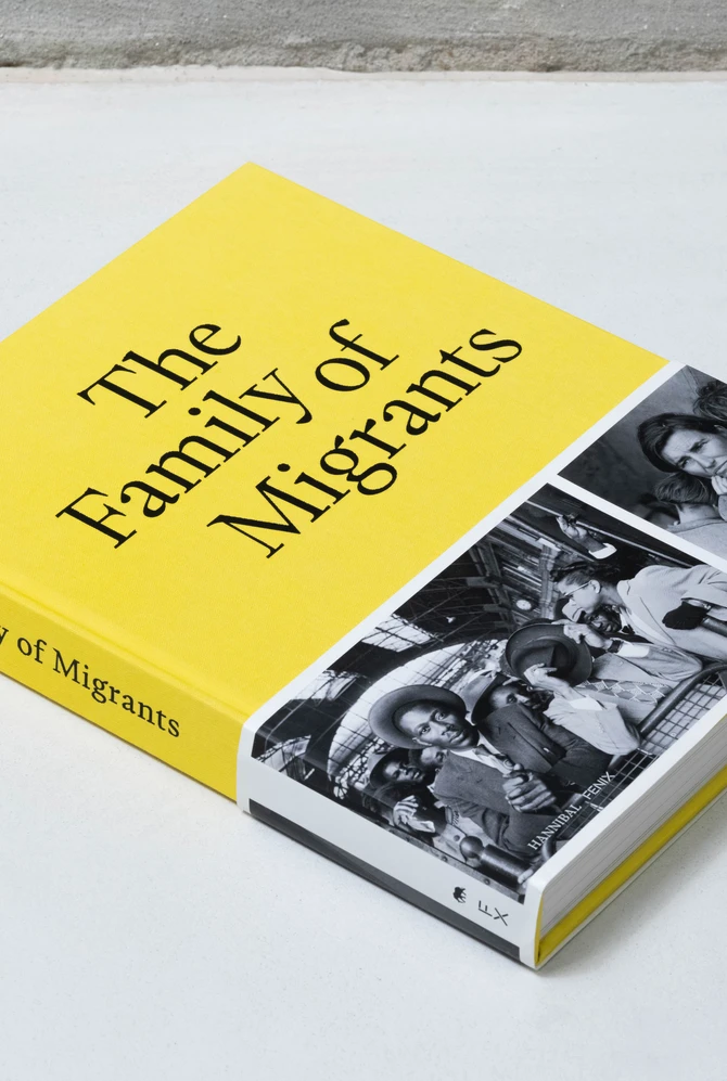 een boek ligt op een neutrale ondergrond, op de cover een zwart wit foto van een familie