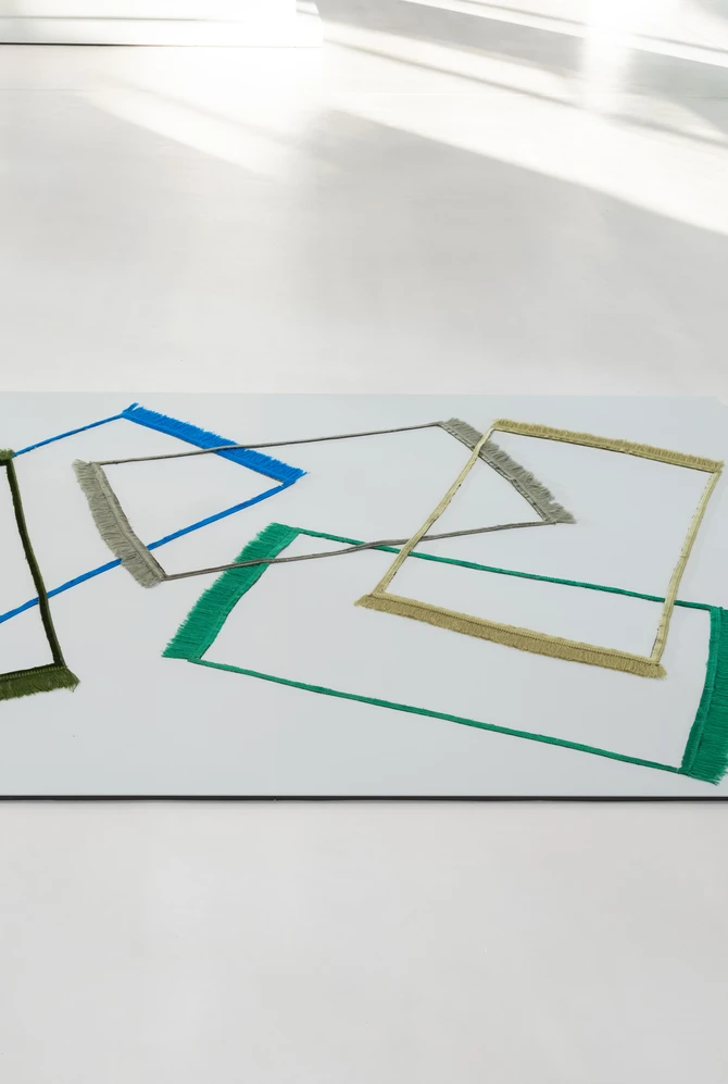 Modern art gallery interior featuring abstract floor art with overlapping colorful lines,