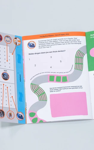 een opengeslagen boekje met kleurrijke vormgeving en illustraties ligt op een neutrale ondergrond