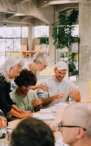 Een man wordt gehopen bij een opdracht door een vrijwilliger, en ze lachen beiden