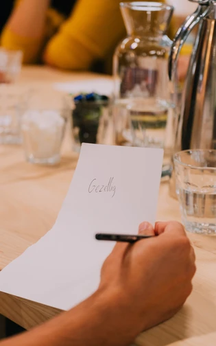 Op een wit vel staat geschreven 'gezellig'