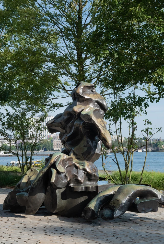 Een groot abstract bronzen beeld staat op de kade voor Fenix.