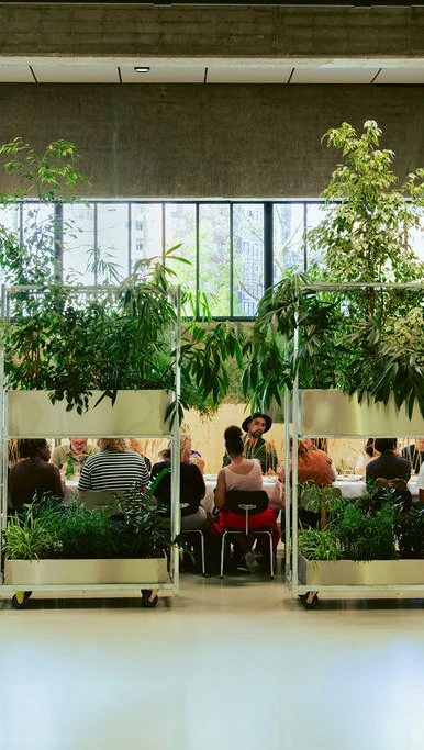 Mensen die aan een lange tafel zitten tijdens een diner op Plein, bij Fenix.