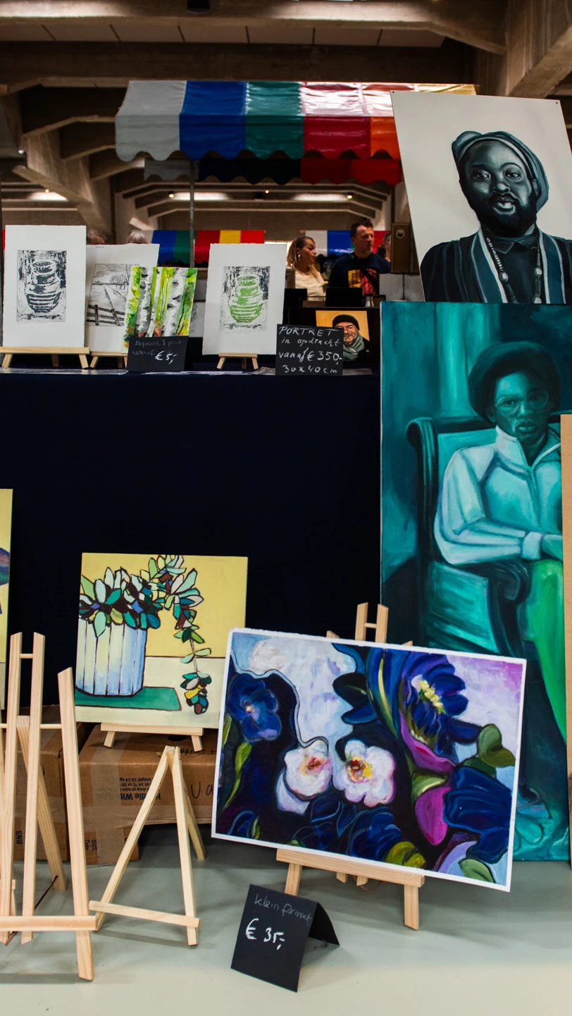 Colourful market stalls display paintings, prints and handmade artworks inside Fenix.