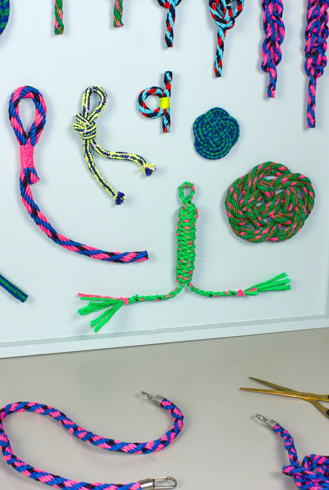 A colourful display of knotted ropes and cords with tools on a worktable.