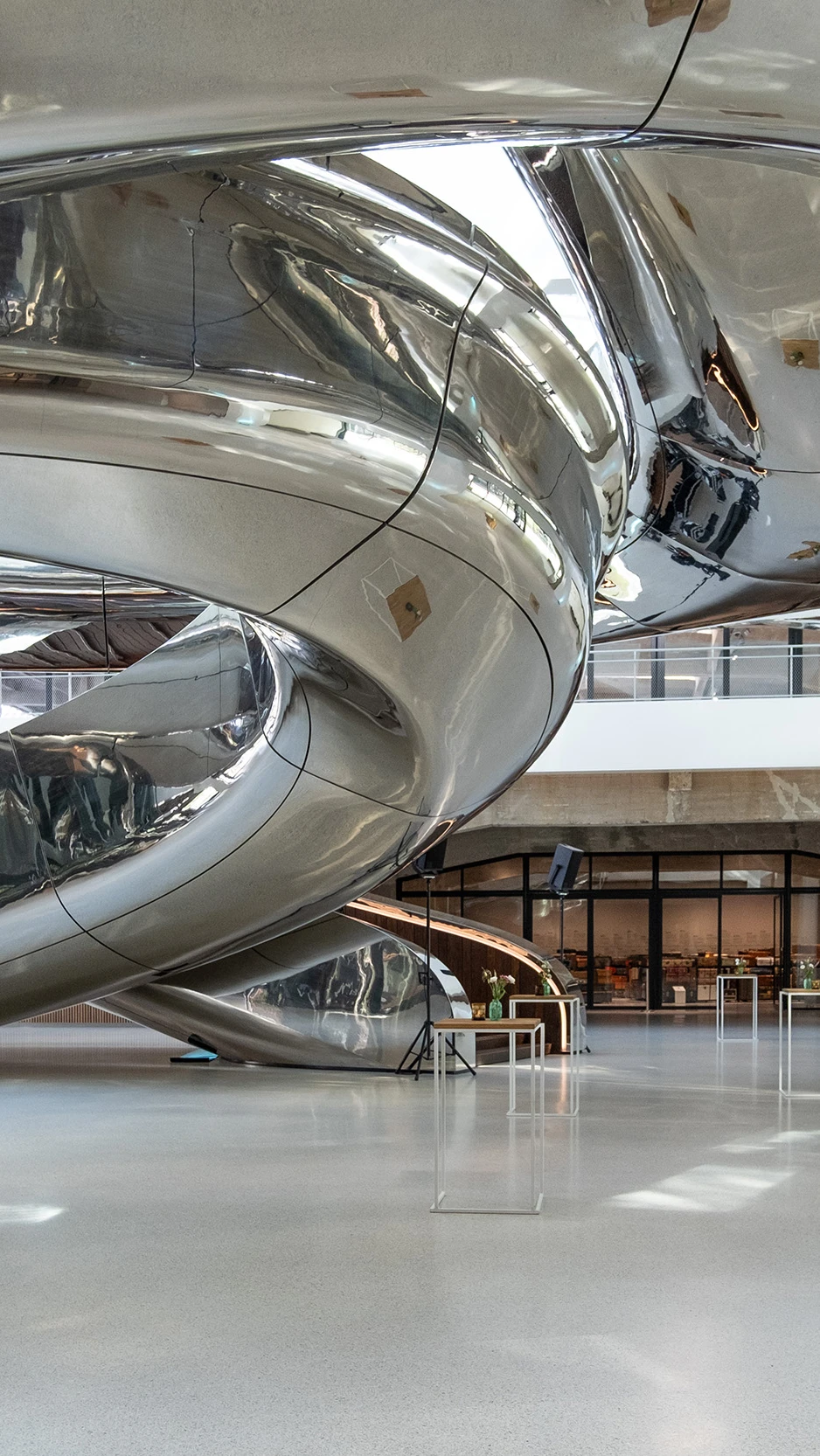 Een grote metalen spiraaltrap binnen een gebouw, met een moderne en industriële uitstraling.