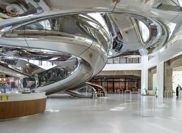 Een grote metalen spiraaltrap binnen een gebouw, met een moderne en industriële uitstraling.