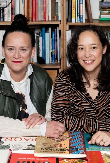 Two women smile at the camera.