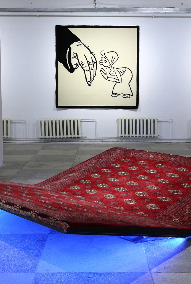 Zwevend rood tapijt in een tentoonstellingsruimte, met zwart-witte wandkleden op de achtergrond