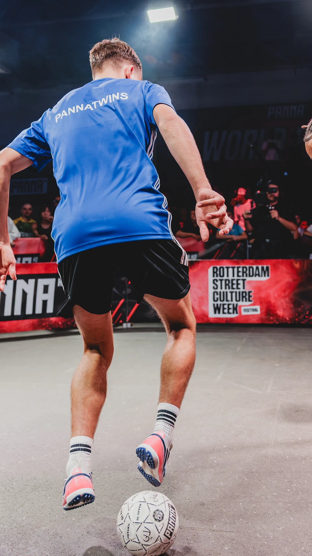 Two street football players face each other over the ball during a panna battle.