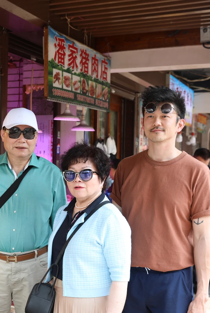 A family standing in front of a Chinese store outside.