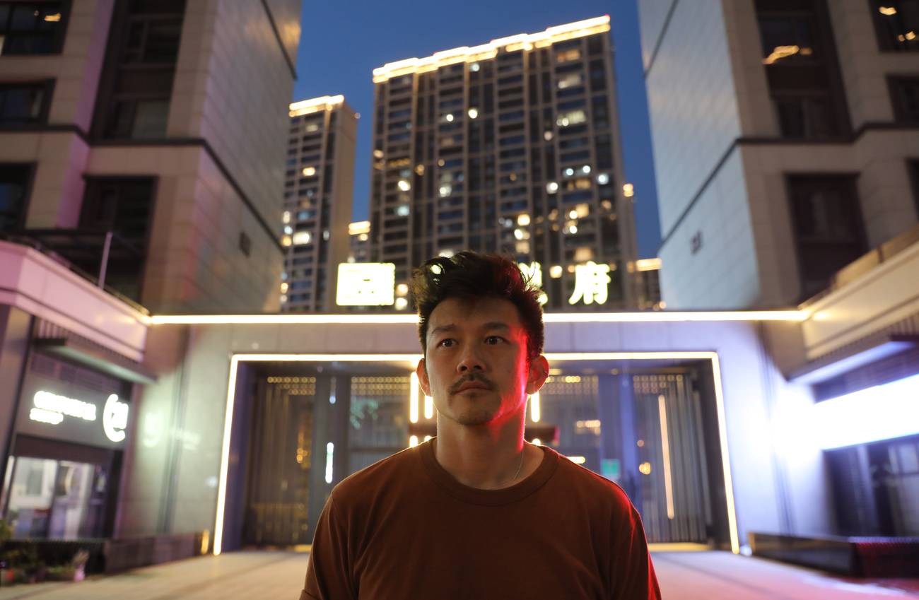 A man standing in the dark in front of a building.