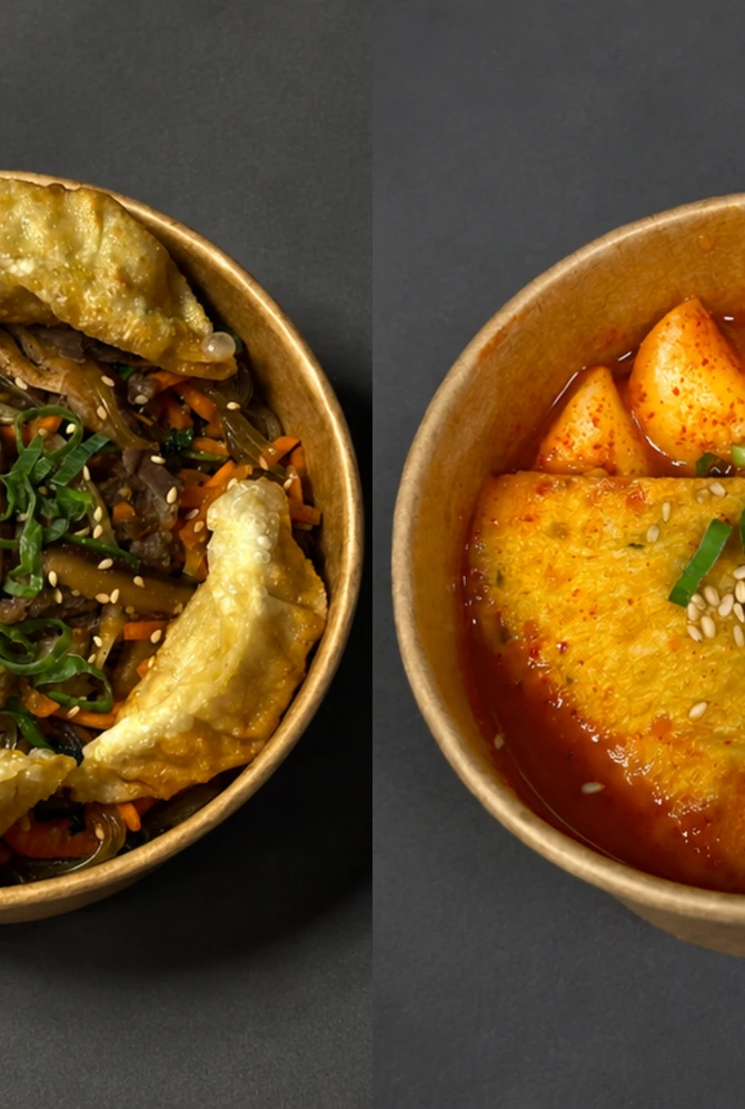 Two bowls of Korean food on a dark surface. Left: noodles with vegetables and fried tofu, garnished
