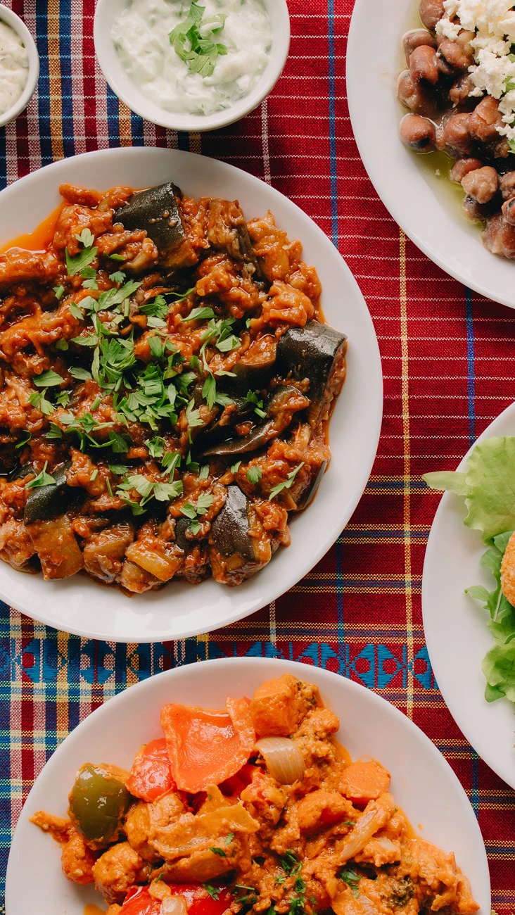 een volle tafel met verschillende gerechten: falafel, aubergine, brood en rijst