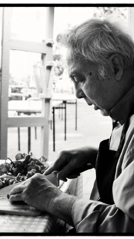 Volunteer preparing food and fresh vegetables in a community kitchen.