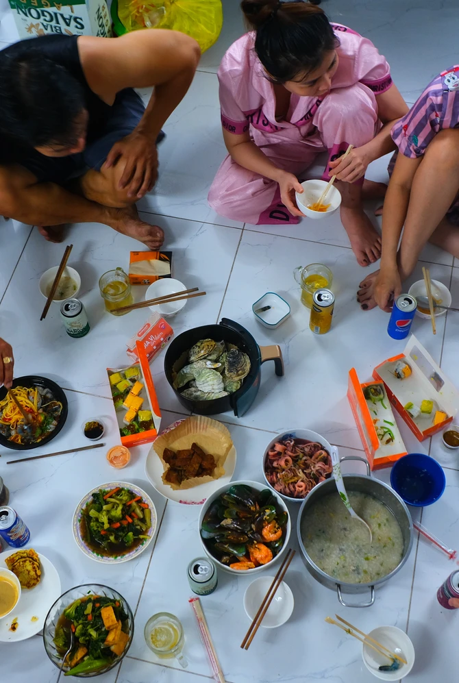 mensen zitten op de vloer en eten verschillende gerechten