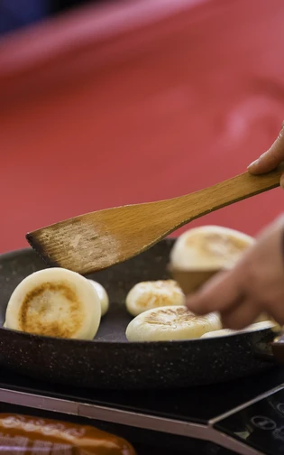 dumplings are made in a pan in a red tent