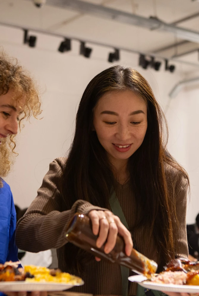 Twee vrouwen met een vol bord eten scheppen op.
